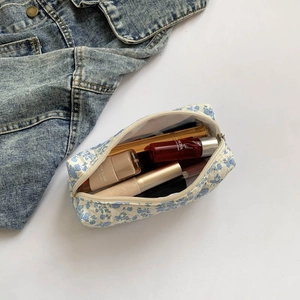 Macro shot showing blue floral makeup bag capacity with cosmetics and denim jacket