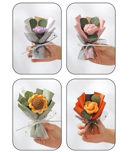 Close-up of handmade knitted mini bouquets with sunflower and rose in colorful wrapping