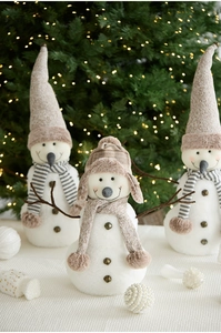 Detailed view of plush snowman dolls with knit hats and golden bells for holiday decor