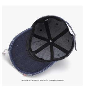 Detail of distressed navy denim baseball cap interior with black tape and metal buckle