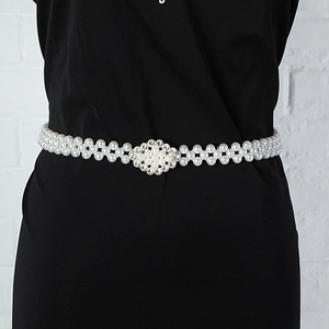 Close-up of elegant double-row pearl waist chain with ornate gold buckle on black dress