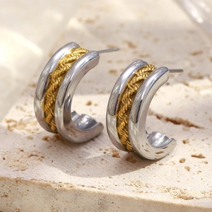 Détail de boucles d'oreilles en C bicolores avec torsade dorée et bordure argentée