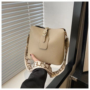 Detail of khaki bucket bag showing lychee pattern leather and golden adjustable buckle
