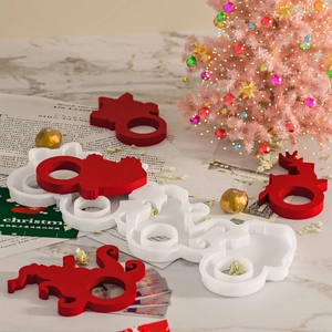 Festive red and white reindeer napkin rings and Christmas ornaments on marble surface
