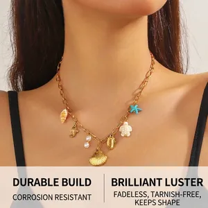 Close-up of gold chain necklace with seashell, sea turtle and starfish charms