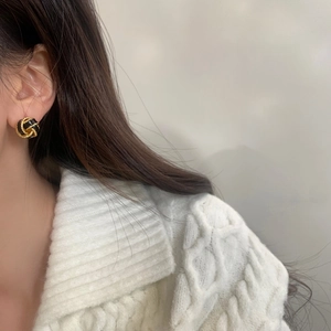 French vintage knot stud earrings in black and gold finish worn by a model