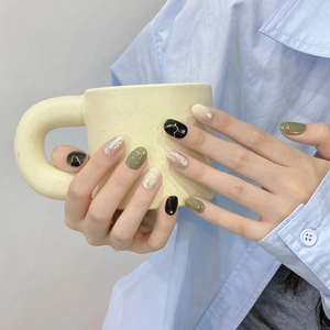 Faux ongles faits main vert olive et noir avec des détails de paillettes dorées