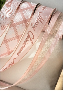 Detail of pink and rose gold Merry Christmas velvet ribbons with festive patterns
