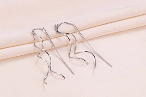 Detailed macro view of S925 sterling silver spiral threader earrings on fabric