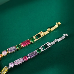 Detail of colorful zircon pavé chain bracelets with gold and silver fold-over clasps