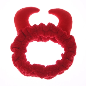 Gros plan d'un bandeau en peluche rouge avec cornes de diable pour le lavage du visage