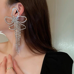 Macro detail of oversized floral ear cuff with sparkling rhinestone tassels on model