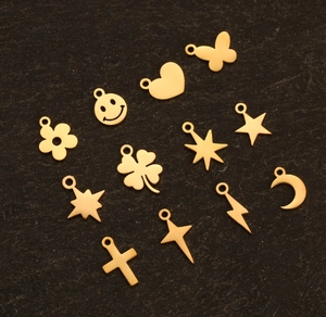 Flat lay of small gold stainless steel DIY pendants in heart star and butterfly shapes