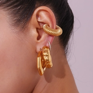 Close-up of 18K gold crescent earrings and textured ear cuffs on model ear