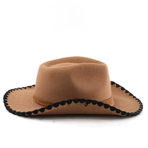 Detail of brown felt cowboy hat featuring black woven whipstitch edge and retro western style