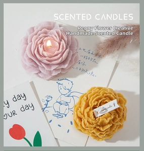 Dettaglio ravvicinato di candele a forma di peonia realistiche in rosa e giallo con etichetta