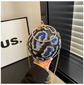 Close-up of a spherical sequin evening bag with a crystal-encrusted ring handle and gold chain