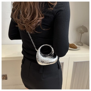Gros plan d'un sac boîte en acrylique argenté avec texture martelée et chaîne