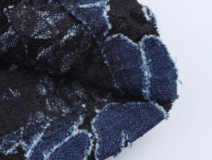 Detail of blue denim and black lace patchwork with distressed frayed edge craftsmanship