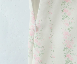 Détail du tissu à fleurs avec une fermeture éclair blanche invisible sur l'ensemble