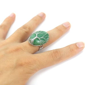 Macro detail of handmade wire-wrapped tree of life ring with green crystal gemstone
