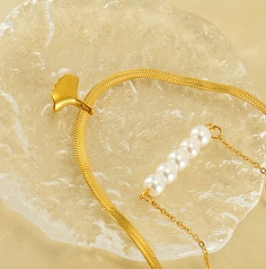 Detail of 18K gold-plated double-layer necklace with ginkgo leaf and white pearls