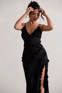 Détail de la robe noire avec décolleté en V profond, bordures volantées et fente latérale