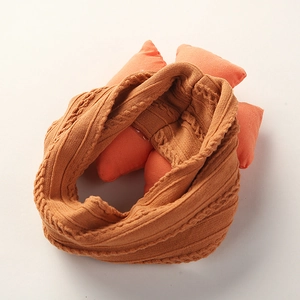 Detailed close-up of orange-brown cable knit texture on a soft baby nylon headband