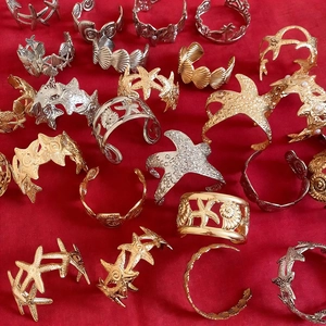 Sammlung von Vintage-Armreifen in Gold und Silber mit dekorativen Seesternen und Muscheln