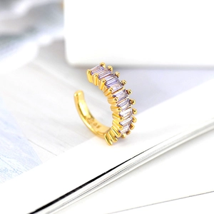 Detail of 18k gold C-shaped ear cuff featuring elegant baguette-cut purple zircon stones
