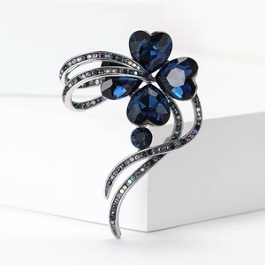 Detailed macro view of four-leaf clover brooch with dark blue gems and rhinestones
