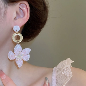Detailansicht der perlmuttfarbenen Blumenohrringe mit goldenem Metallring und Perlenstecker