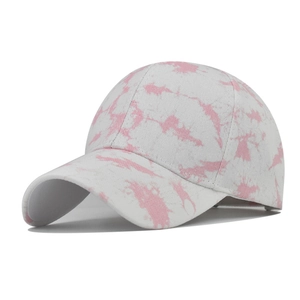 Macro detail of pink tie-dye pattern on 6-panel cotton fabric baseball cap with stitching