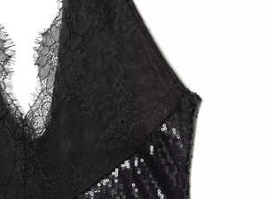 Detailed macro shot of black lace stitching and shimmering sequins on the neckline