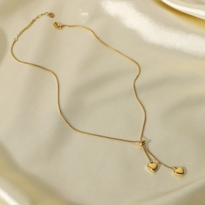 Elegante collana a Y in acciaio al titanio dorato con due pendenti a cuore su seta champagne