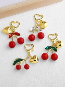 Détail de divers porte-clés cerise avec pendentifs cœur et feuilles en cristaux colorés