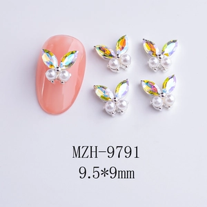 Macro detail of cherry butterfly nail charm with gradient rhinestones and white pearls
