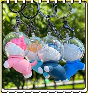 Close-up of four colorful silicone astronaut cat keychains in outdoor settings