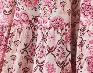 Close-up of pink floral print fabric with bohemian patterns on a lightweight midi skirt