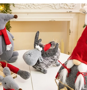 Close-up of plush Christmas gnomes and reindeer ornaments on a cozy white tabletop