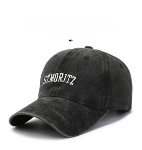 Detail of white 3D embroidered ST. MORITZ lettering on a black washed denim baseball cap