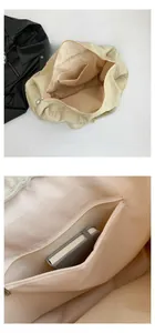 Detail view of the spacious inner lining and zipper pocket of the beige quilted tote bag