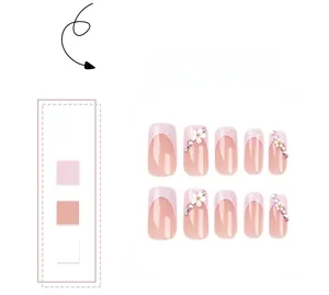 Detail of pink French press-on nails with 3D floral accents and sparkling rhinestones