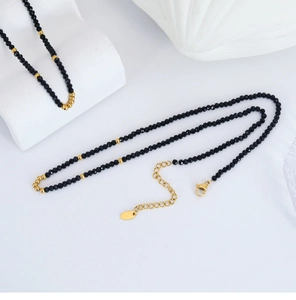 Detail of black faceted beads and gold metal accents on a handcrafted elegant necklace