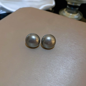 Detailed view of large grey pearls with metallic luster on elegant beige textured surface