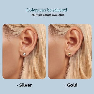 Detail of minimalist oval metallic stud earrings in polished silver and gold finishes