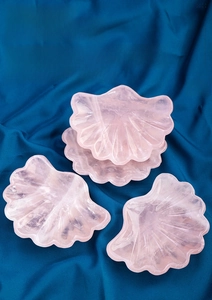 Vista dettagliata della ciotola in quarzo rosa a forma di conchiglia su seta blu