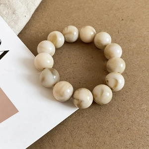 Detail of round acrylic beads with brown marble texture and smooth polished finish