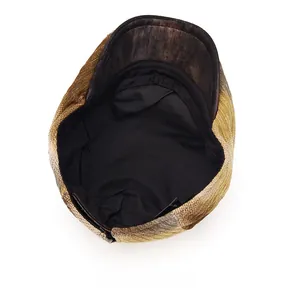 Detail view of newsboy cap interior featuring black lining and brown leather brim texture