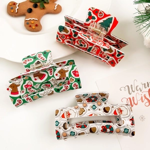 Détail de trois pinces à cheveux en acrylique aux motifs festifs de rennes et de Père Noël